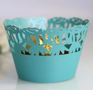 Detail of teal laser-cut rose lace cupcake wrapper with decorative floral patterns
