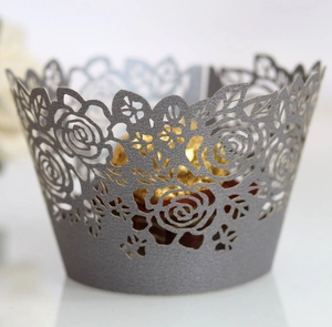 Close-up of laser-cut rose cupcake wrapper in grey with a golden chocolate ball