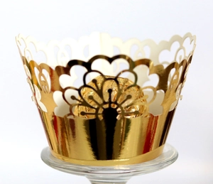 Laser-cut gold cupcake wrapper with hollow heart patterns for wedding decorations