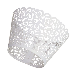 Macro view of white laser cut hollow lace cupcake wrappers with intricate floral patterns