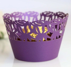 Macro detail of laser-cut purple cupcake wrapper with intricate rose floral patterns