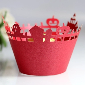 Macro shot of laser-cut red Halloween cake wrappers with ghost and castle patterns