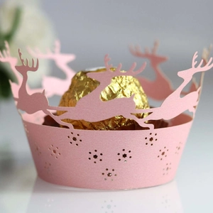 Pink laser-cut Christmas reindeer cupcake wrappers with hollow star patterns