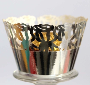Close-up of laser-cut rose hollow cupcake wrappers in reflective metallic silver finish