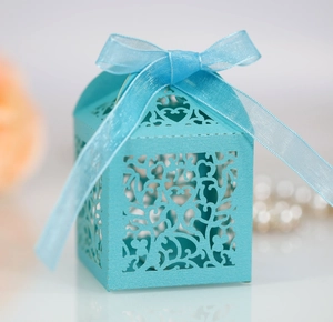 Detail of light blue laser-cut candy box with heart patterns and ribbon bow