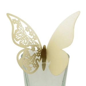 Pale gold 3D butterfly place card with hollow pattern on a glass rim for wedding decor