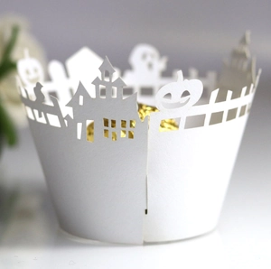 Macro shot of white laser-cut Halloween cupcake liners with pumpkin and castle patterns