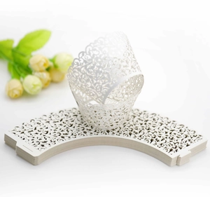 Macro detail of laser-cut cupcake wrappers with white floral scroll pattern