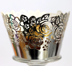 Close-up of laser-cut rose hollow cupcake wrapper with silver metallic finish texture