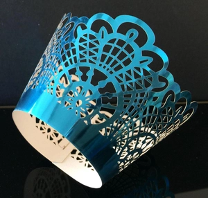 Detail of laser-cut cupcake wrappers with blue metallic finish and intricate lace texture