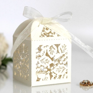 Détails de feuilles découpées au laser sur boîte à bonbons blanc perle avec ruban en soie