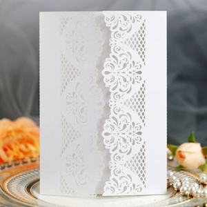 Elegant laser-cut floral wedding invitation on white pearlescent paper with luxury decor