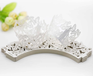 Detailed laser-cut white butterfly cupcake wrappers for wedding cake decorations