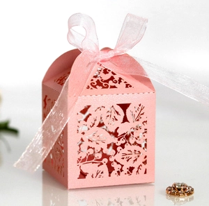 Détail de la boîte cadeau rose découpée au laser avec motifs de feuilles et ruban
