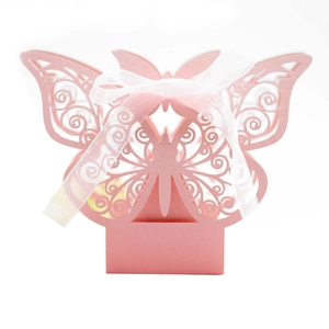 Detail of pink laser-cut butterfly candy box featuring pearlescent paper and white ribbon bow