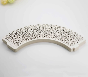 Macro view of white laser-cut vine lace cupcake wrappers with elegant vine pattern detail