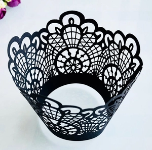 Intricate laser-cut black lace cupcake wrappers with detailed geometric hollow patterns