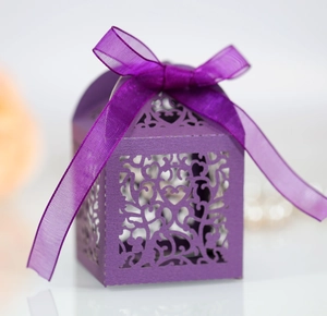 Detail of purple laser-cut lace candy box with elegant floral patterns and ribbon bow