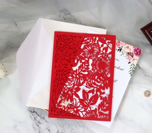 Détail de l'invitation de mariage rouge découpée au laser avec insert floral élégant