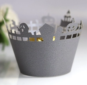 Macro shot of laser-cut Halloween cupcake wrapper with ghost and pumpkin motifs