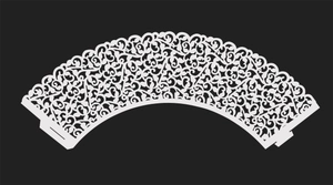 Close-up of white laser-cut cake cupcake wrapper with intricate vine lace patterns