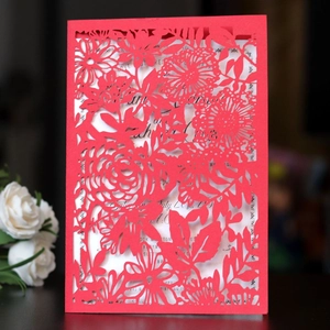 Détails de découpe laser florale sur une invitation de mariage rouge avec carte blanche
