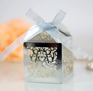 Detailed view of silver laser-cut candy box with blue ribbon for wedding party favors