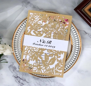 Détail de l'invitation de mariage découpée au laser avec pochette florale et bandeau