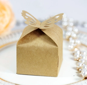 Brown kraft paper wedding candy box with laser-cut butterfly lid on elegant ceramic plate