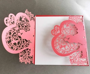 Detailed laser-cut wedding invitation featuring heart patterns and couple silhouette