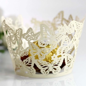 Close-up of laser-cut butterfly cupcake wrapper in cream white with gold chocolate