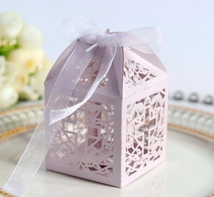 Detailed laser cut floral pattern on a light purple wedding favor box with a white ribbon