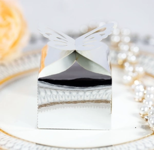 Detail of silver mirror wedding favor box with laser-cut butterfly on a decorative plate