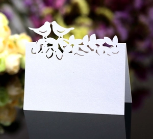 Détail macro de marque-places de mariage découpés au laser avec oiseaux et motifs floraux