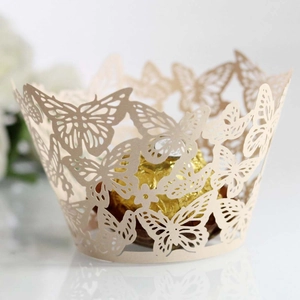 Close-up of laser-cut ivory butterfly cupcake wrapper with gold sphere chocolate