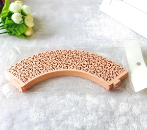 Detailed laser-cut vine lace cupcake liners in soft apricot pink for elegant baking