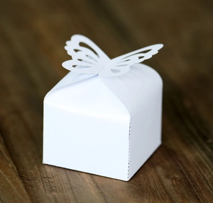 Detail of laser-cut butterfly clasp on white wedding favor box for chocolate and candy