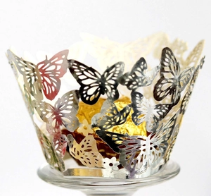 Macro view of laser-cut butterfly cupcake wrappers in metallic pearl paper for weddings