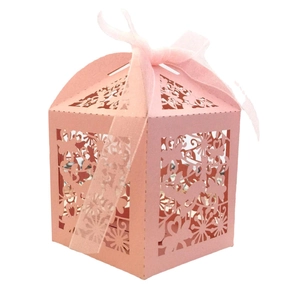 Close-up of pink laser-cut gift box with floral patterns and a matching ribbon bow
