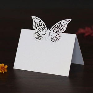 Macro view of laser-cut butterfly seat card with pearl white finish on wood