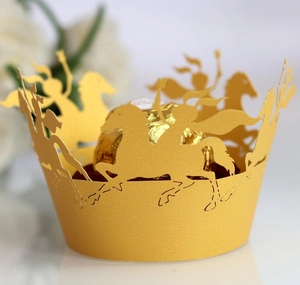 Detail of laser-cut gold cupcake wrapper with horse pattern and chocolate center