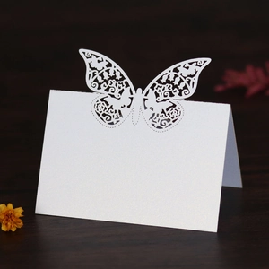 Macro detail of laser-cut butterfly place card with elegant white pearlescent finish