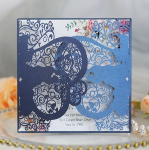 Detail of laser-cut hollow wedding invitation with navy glitter cover and floral insert