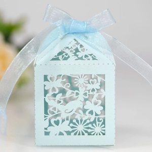 Detail of light blue laser-cut candy box with bird patterns and ribbon bow