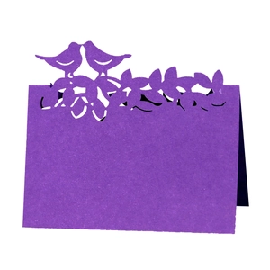 Détail du marque-place violet découpé au laser avec motif d'oiseaux et d'arbres