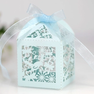 Detail of laser-cut bird and flower pattern on light blue gift box with ribbon