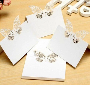 Detailed laser-cut butterfly place cards with intricate hollow mesh wings for weddings