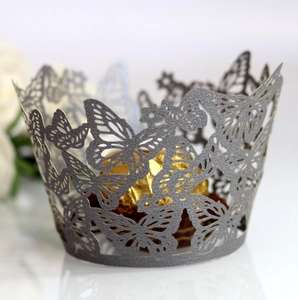 Detailed laser-cut silver butterfly cupcake wrapper with intricate pearlescent paper hollow design