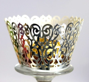 Macro view of silver hollow lace cupcake wrappers with intricate floral laser cut design