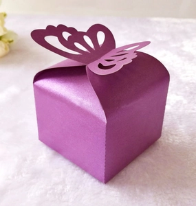 Detail of dark purple wedding favor box featuring laser-cut butterfly and pearlescent paper